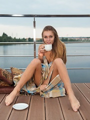 Katie A sips on her coffee as she enjoys the cool, balmy air on her naked body. - Pics